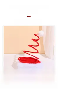 Detail of red spring spiral Christmas hat with white plush trim and fuzzy pompom
