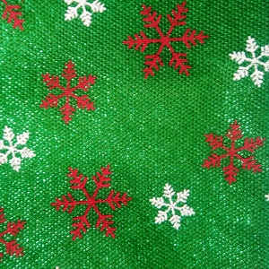 Grüner Sackleinen-Weihnachtsstoff mit roten und weißen Schneeflocken für festliche Dekoration