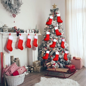 Detail of twelve red Christmas stockings with gold trim hanging in a festive indoor scene