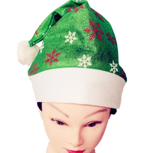 Detail einer grünen Glitzer-Weihnachtsmütze mit Schneeflocken und weißem Plüschrand