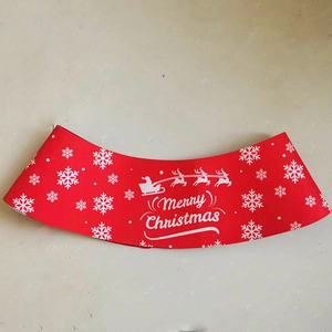 Close-up of red Christmas coffee cup sleeve with white snowflake and Santa sleigh patterns