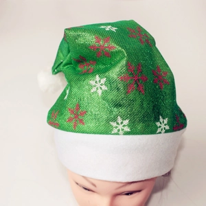 Detailansicht der grünen Pailletten-Weihnachtsmütze mit weißem Pelzrand und Schneeflocken