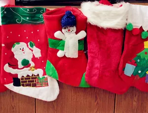 Detail view of four red Christmas stockings with plush trim and festive 3D characters