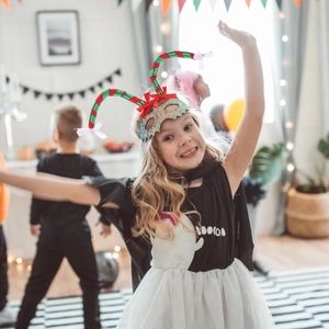 Detail view of festive Christmas headband with striped candy patterns and red bow for kids