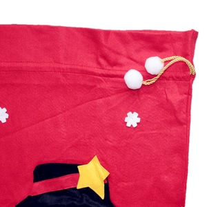 Detail view of red felt Christmas gift bag with black top hat and gold drawstring