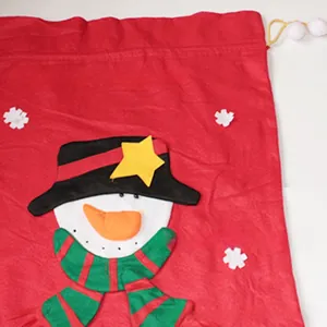Detail of red Christmas drawstring gift bag featuring a 3D plush snowman and striped scarf