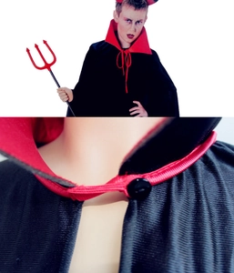 Detail of the stand-up red collar and fastening button on a black vampire cloak