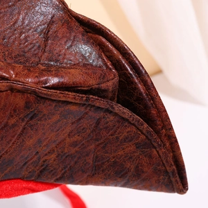 Vintage brown pirate hat with distressed leather texture and decorative red lace tie