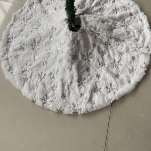 Detailed view of silver sequin snowflake embroidery on a plush white Christmas tree skirt