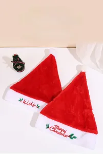 Detailed view of red plush Christmas hats with kids and Merry Christmas embroidery