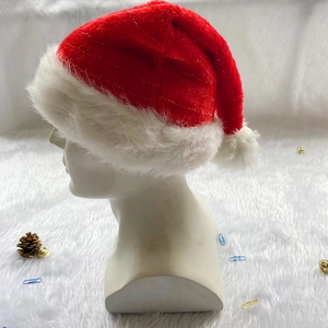 Detail of red plush Christmas hat with gold thread and white pom-pom on model