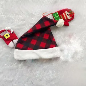 Flat lay of a red and black buffalo plaid Christmas hat with white faux fur trim on plush rug