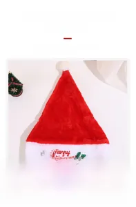 Detailed view of Merry Christmas embroidery on a red plush holiday hat with pom-pom