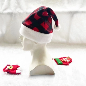 Close-up of red and black buffalo plaid Christmas hat with soft white plush trim and pompom
