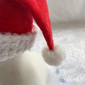 Detail of red festive Christmas hat with silver sequins on white plush trim and soft pom-pom