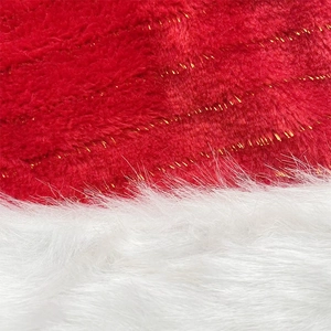 Close-up detail of plush red fabric with gold tinsel and soft white faux fur on Christmas hat