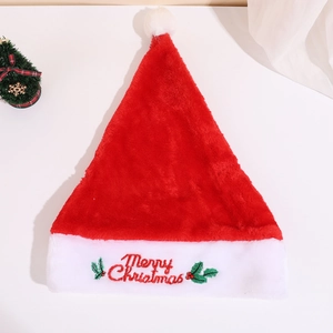 Plush Christmas hat with Merry Christmas embroidery and holly leaf decor on a white table