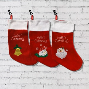 Close-up of three red Christmas stockings with plush white cuffs and festive embroidery