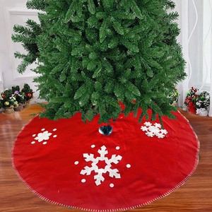 Red Christmas tree skirt with white snowflake patterns on a wooden floor base