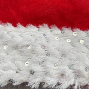 Macro shot of red plush Christmas hat fabric with white faux fur trim and silver sequins
