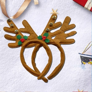 Détail de serre-tête bois de renne avec clochettes et baies dans un décor festif de Noël
