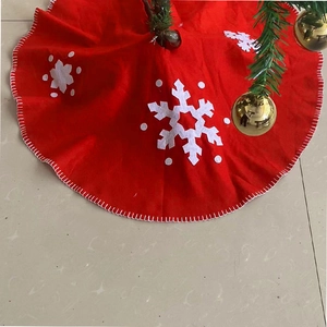 Red Christmas tree skirt with white snowflake patterns and decorative white stitched edges
