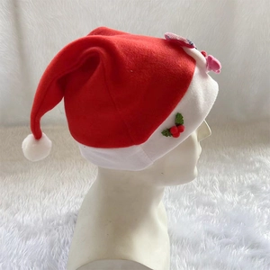 Classic red Santa hat with white trim and green holly berry leaf accent on fuzzy fabric