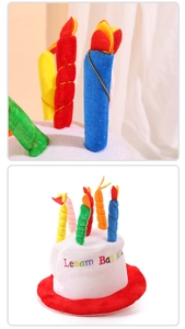 Close-up of plush birthday cake hat with colorful candles and embroidered lettering details