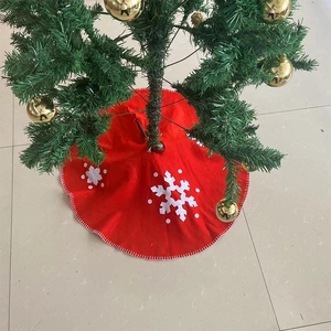 Detail of red Christmas tree skirt with white snowflake embroidery and stitched edges