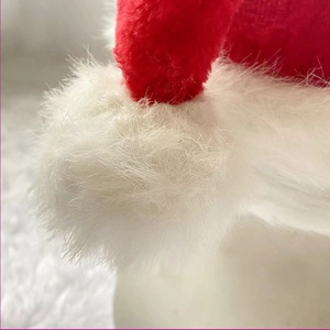 Macro shot of soft plush Christmas hat texture with fluffy white faux fur pompom and brim