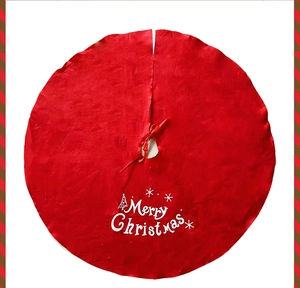Detail of red Merry Christmas tree skirt with white snowflake patterns and ribbon ties