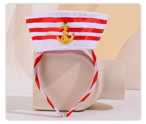 Detail of nautical headband featuring white and red stripes with a gold anchor ornament