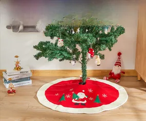 Detailed view of red Christmas tree skirt with Santa embroidery and white plush trim