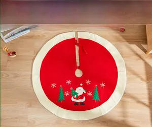 Detail view of red Christmas tree skirt with festive embroidery on wooden floor
