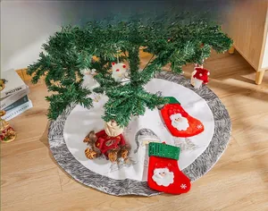 Detail of white plush Christmas tree skirt with red sequin stockings and 3D Santa dolls