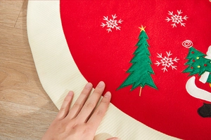 Close-up of premium embroidered Christmas tree skirt showing plush texture and festive patterns