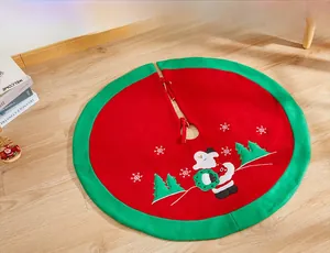 Detail of red Christmas tree skirt with Santa Claus embroidery and festive green border