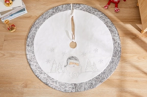 Detail of plush white Christmas tree skirt with embroidered Santa and silver faux fur edge