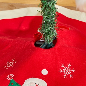 Classic red felt Christmas tree skirt with white embroidery and Santa Claus pattern decoration