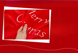 Detailed close-up of plush red Christmas fabric with white Merry Christmas embroidery