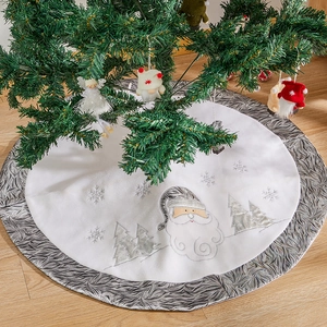 White plush Christmas tree skirt with silver embroidered Santa and snowflake patterns