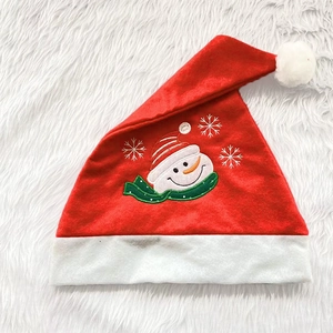 Plush red Christmas hat featuring embroidered snowman and snowflakes on soft fur background