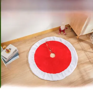 Detail of red and white plush Christmas tree skirt with ribbon ties on wood floor