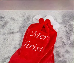 Close-up of red plush Christmas gift bag with white embroidery and drawstring
