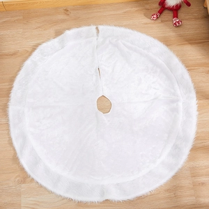 Plush white faux fur Christmas tree skirt with round opening on wooden floor background