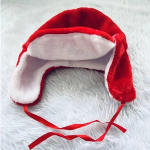 Plush red and white Christmas trapper hat with soft faux fur lining and red ribbon ties
