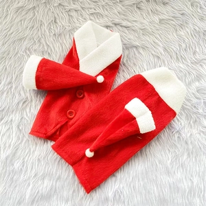 Detail of red plush Christmas wine bottle covers with white fur trim and mini hats