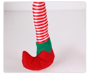 Detail of red and white striped elf legs with green jagged boots for Christmas decor