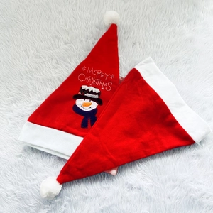 Detail of red plush Christmas hats with snowman embroidery and Merry Christmas text