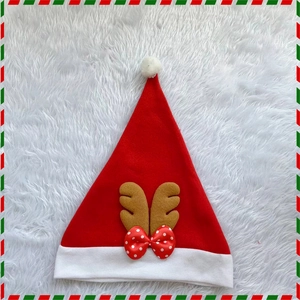 Plush Christmas reindeer hat with brown antlers and red polka dot bow for holiday decor
